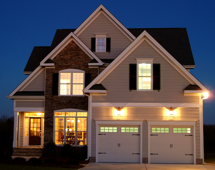 split level single family home at night with interior and exterior lights on